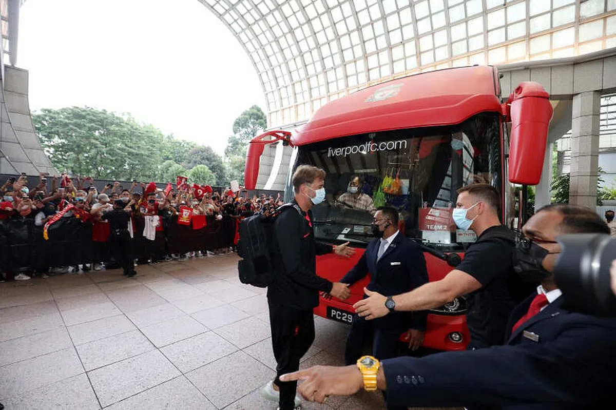 利物浦主帅克洛普（左）在乘坐第一辆巴士抵达酒店后，亲切地与工作人员握手。（邝启聪摄）