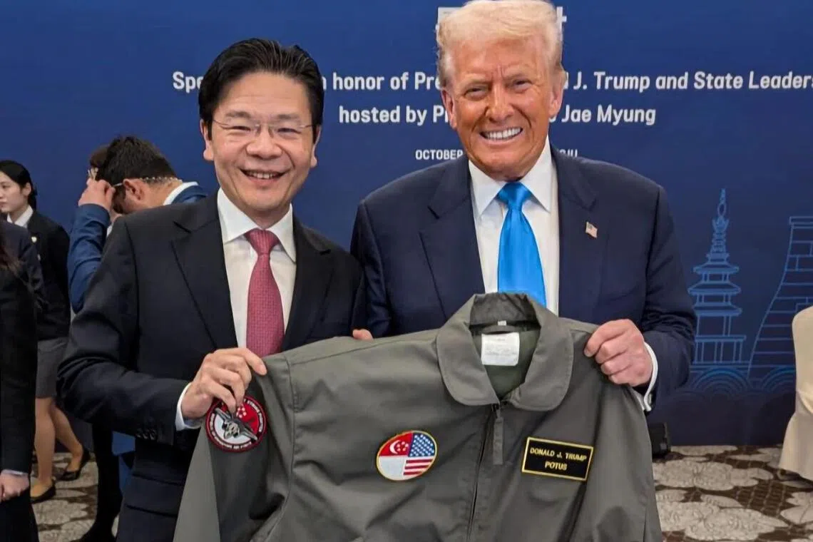 黄循财总理在脸书透露，他于星期三宴会上送了特朗普（右）定制版的新加坡空军部队飞行员夹克。（取自总理脸书）