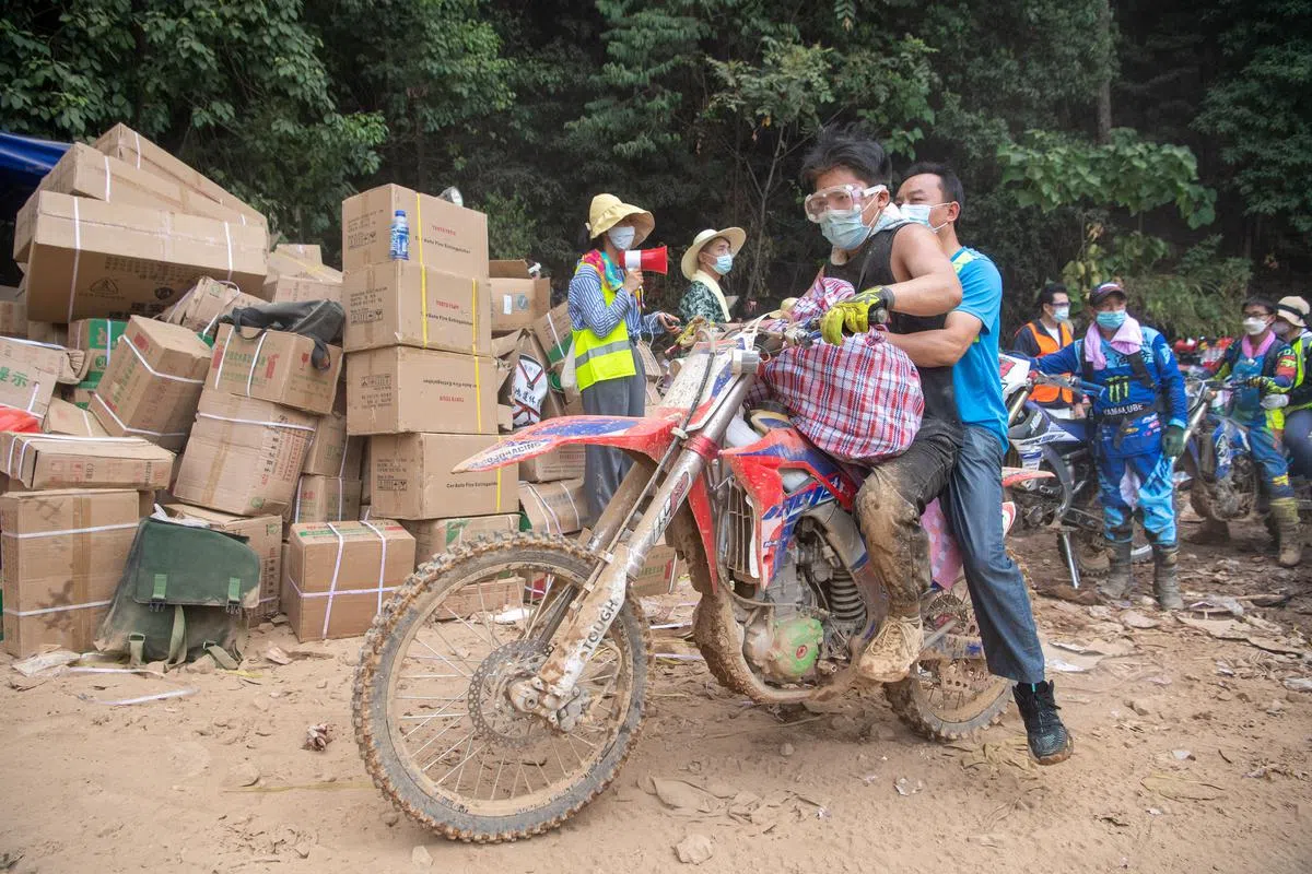 这名志愿者8月26日骑着摩多单车，在重庆北碚运送物资和人员上山。（新华社）