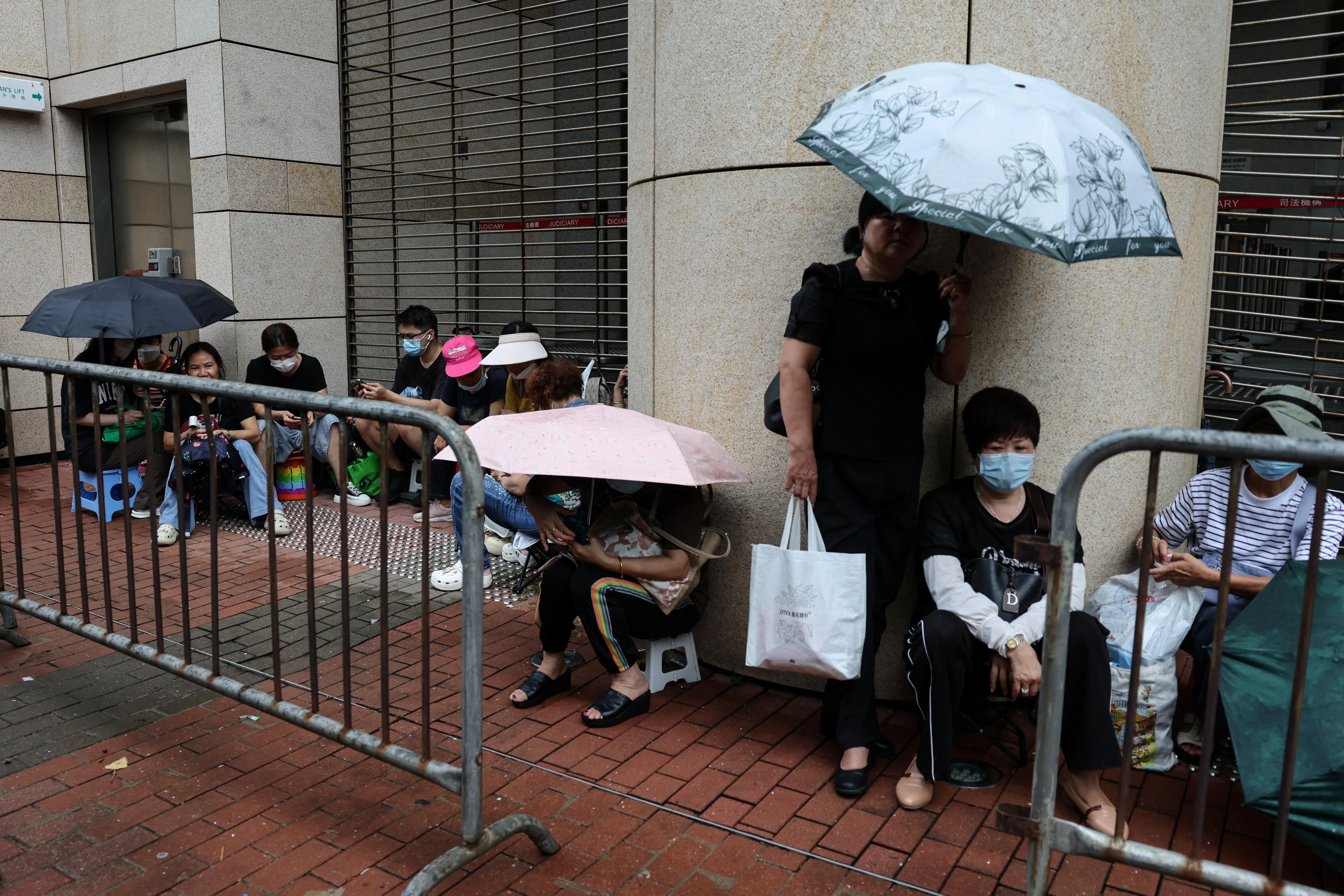 香港法院星期五（8月21日）将对已解散的香港泛民主派组织支联会涉“煽动颠覆国家政权案”作出裁决。图为香港市民当天上午在西九龙法院外等候派筹入庭闻判。（路透社）