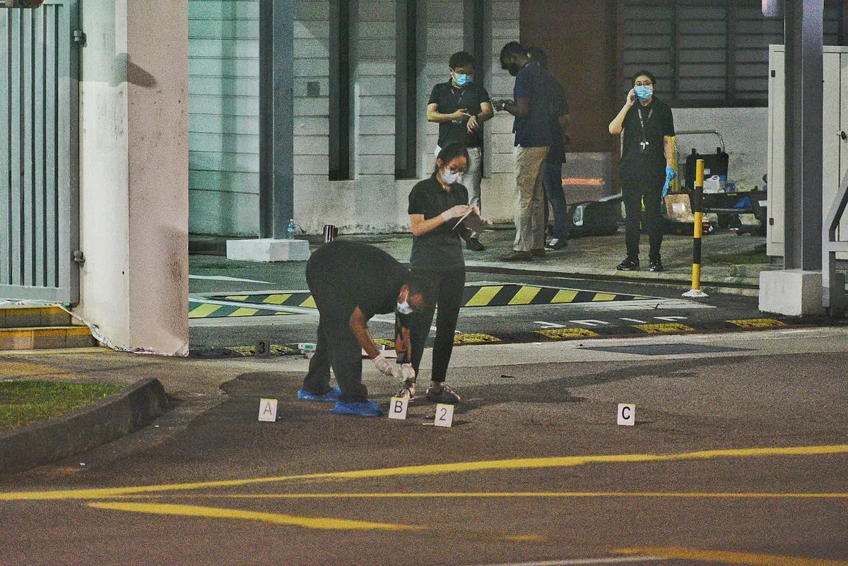 查案人员在金文泰警署外的案发地点放置证物牌和记录现场情况。（档案照）