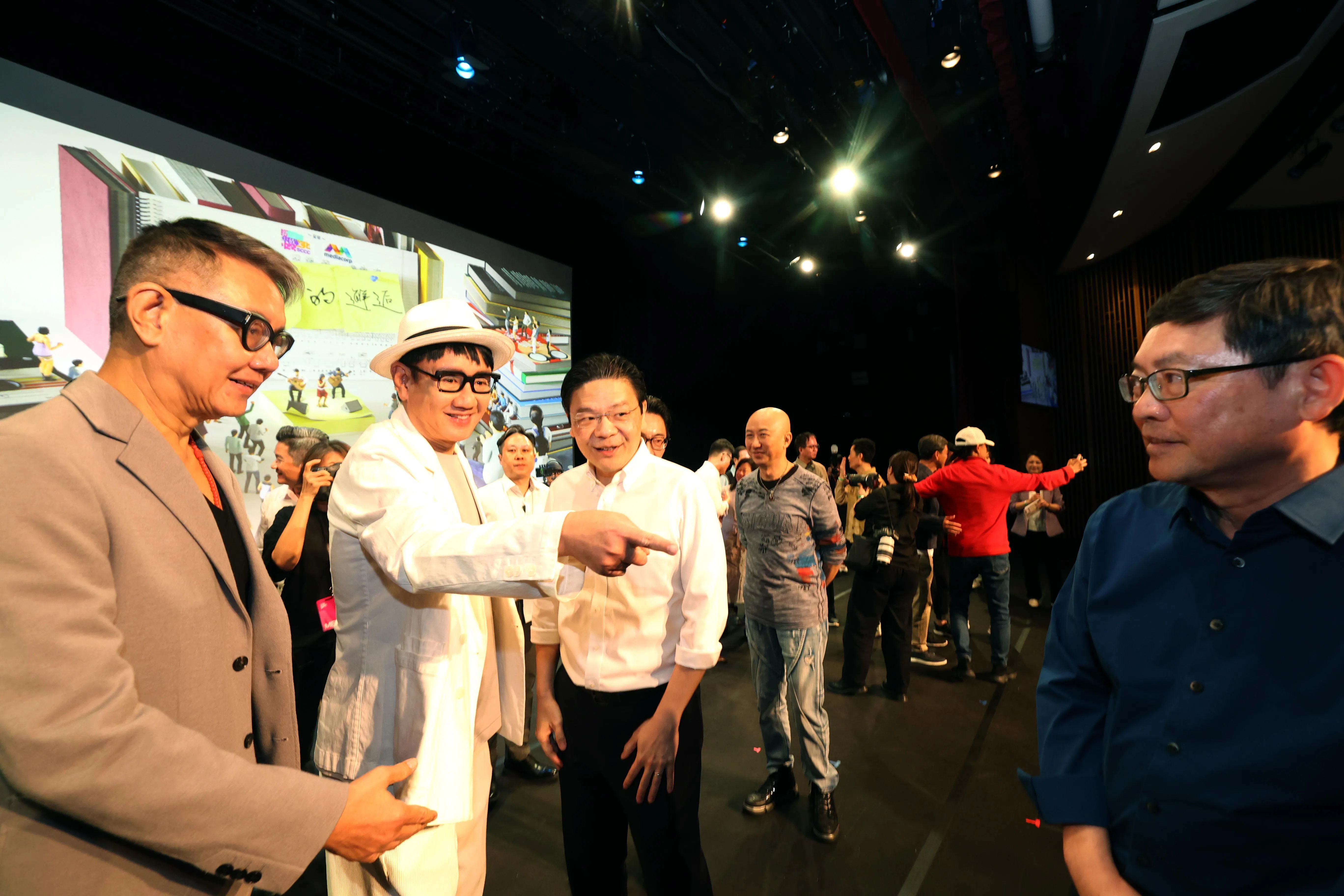 黄循财总理（左三）在纪录片推介会上与李偲菘（左一）和李伟菘（左二）交流。（邝启聪摄）