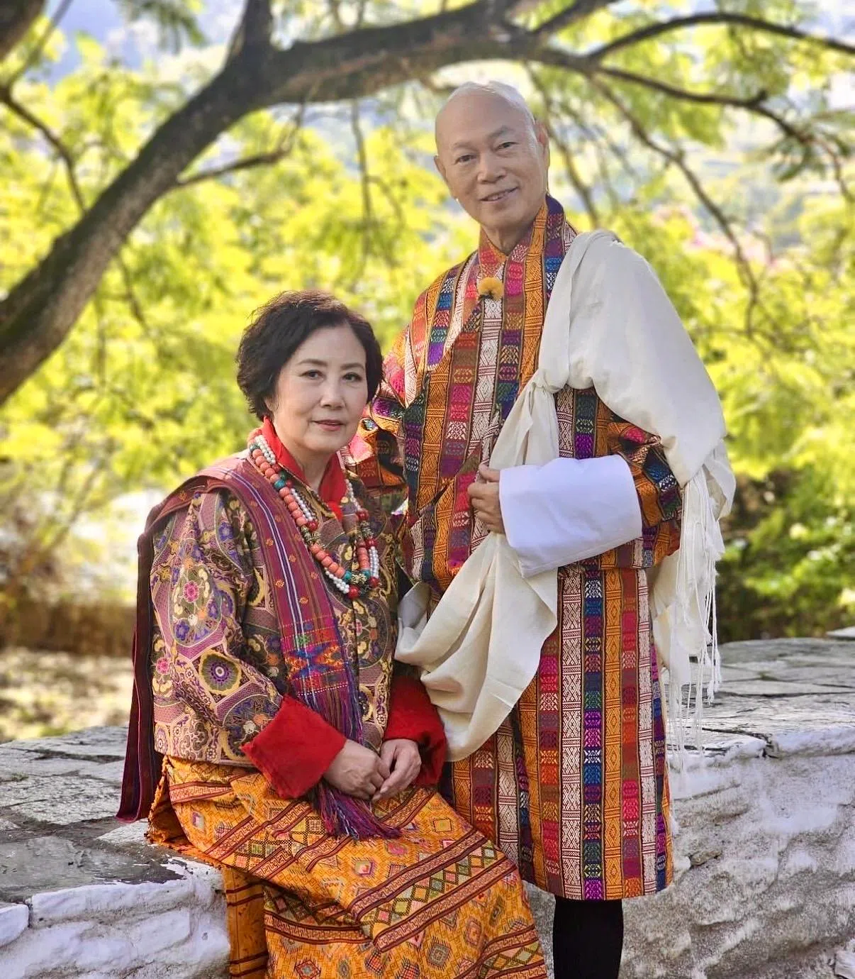 汪明荃（左）和罗家英在2025年TVB旅游节目《带阿姐看世界》中，穿上不丹传统民族服装拍摄结婚照。（取自汪明荃IG）