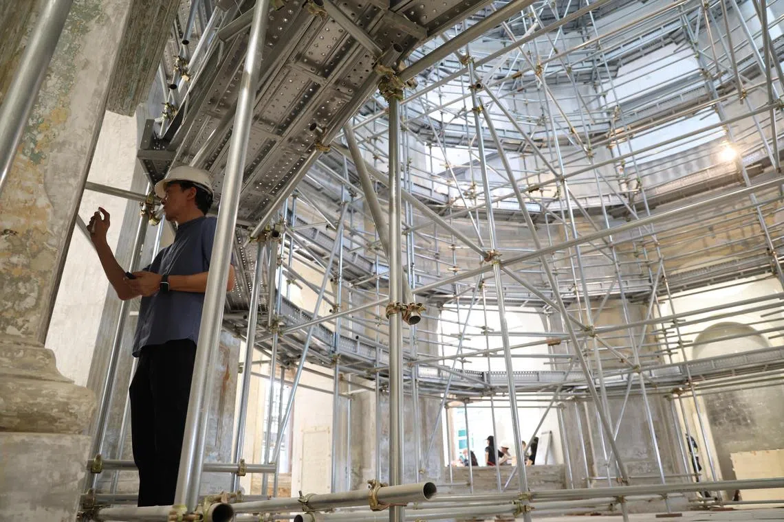 工匠们对国家博物馆圆楼墙体的墙漆进行取样，研究并分析油漆的层次结构，制定最佳的脱漆和重新上色的方案。（林明顺摄）