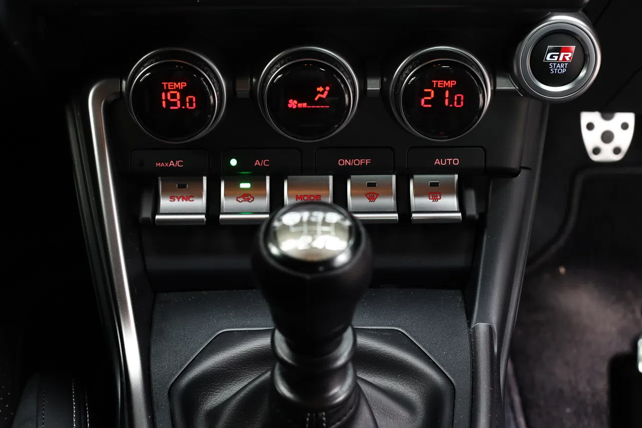 中控屏下的三个圆形冷气调控旋钮及一排金属按钮，看起来很酷。（陈渊庄摄）