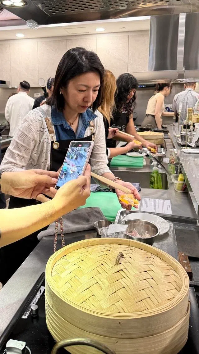 记者看了富临饭店点心师傅林国威的示范后，动手学包烧卖。（主办方提供）