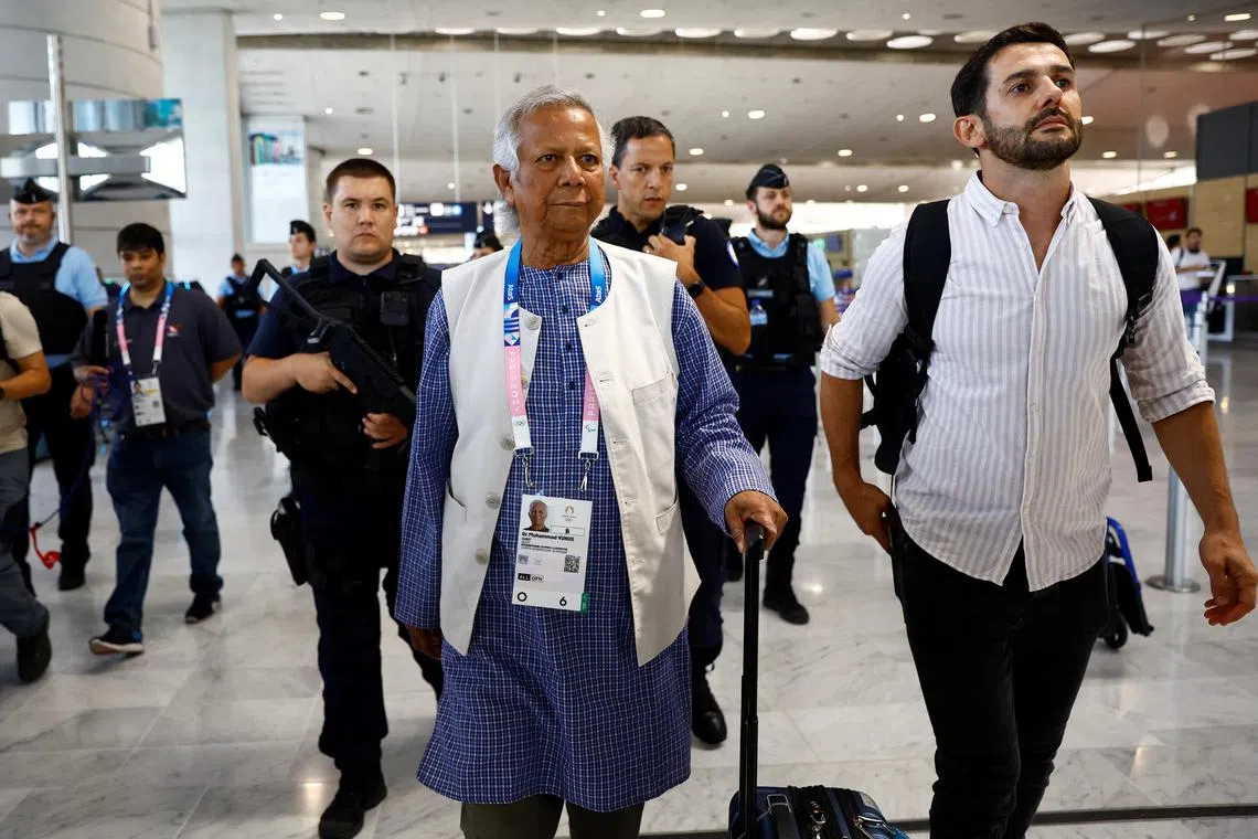 诺贝尔和平奖得主尤努斯（中）8月7日出现在法国巴黎机场，准备登机回返孟加拉。（路透社）