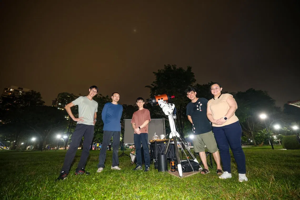 从9月7日深夜到8日凌晨，新加坡科学中心展览部经理孙少军（左二）和同伴们，在西海岸公园为三年来又一次血色月全食，度过了一个不眠之夜。（关俊威摄）