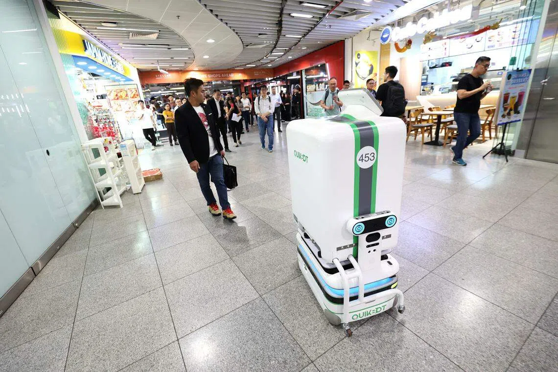 QuikBot机器人能穿梭在电梯与楼宇之间，从滨海中心地铁站的7-Eleven，将订单送到风华南岸的办公楼。（何家俊摄）