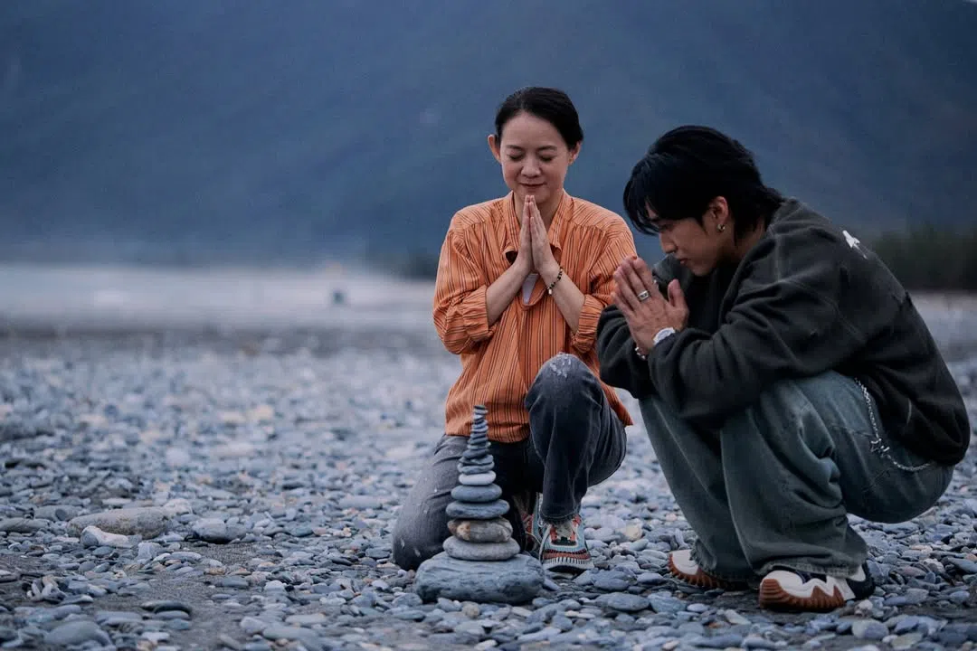 娄峻硕（右）和曾宝仪在花莲的七星潭叠石头祈福。（互联网）