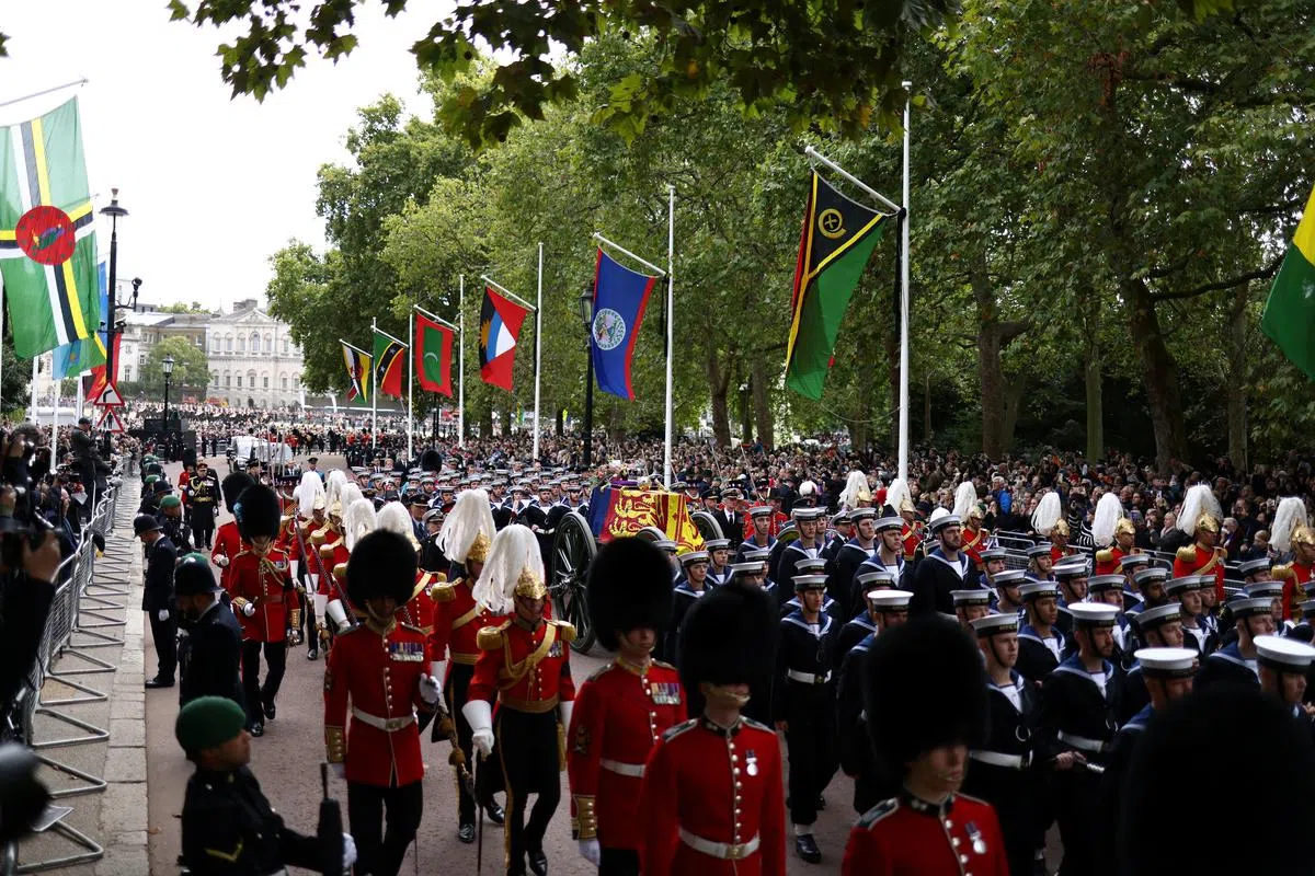 女王灵柩队伍，大批民众夹道送行。（路透社） 