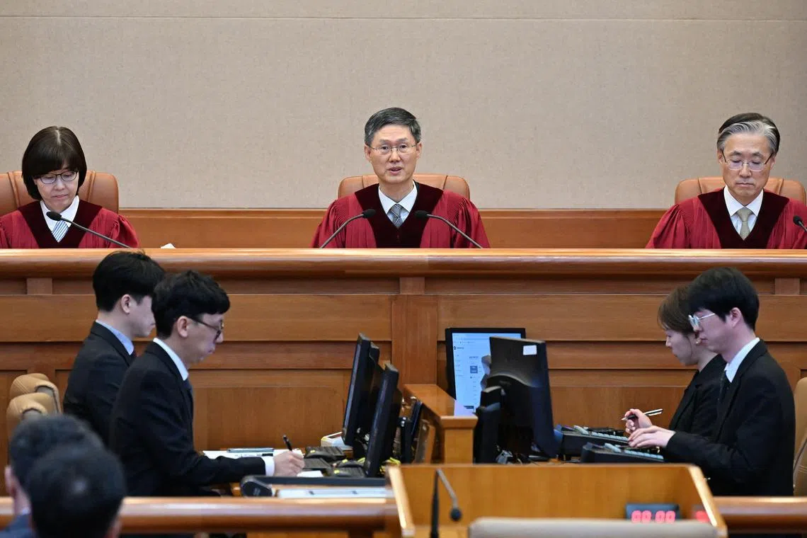 4月4日，宪法法院代理院长文炯培（中）宣读了总统弹劾案裁决书。（法新社）