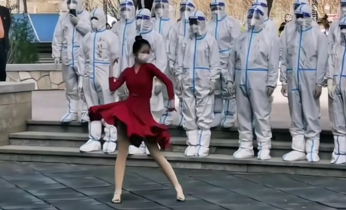 一名身着红裙的女生在一排“大白”面前大跳拉丁舞，被网民批“形式主义”。（互联网）