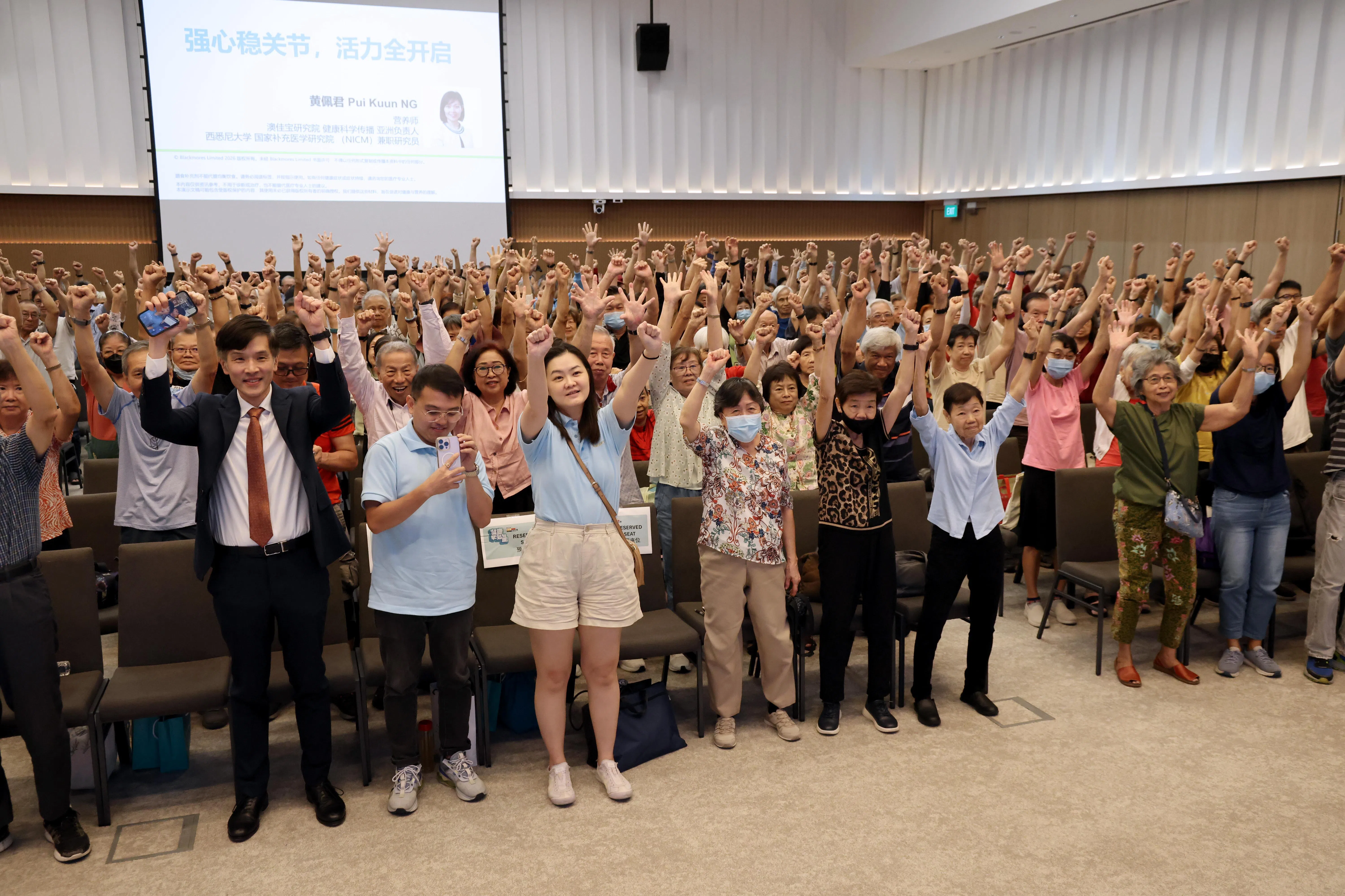 观众跟随资深营养师黄佩君的指示起身做伸展动作。（梁麒麟摄）