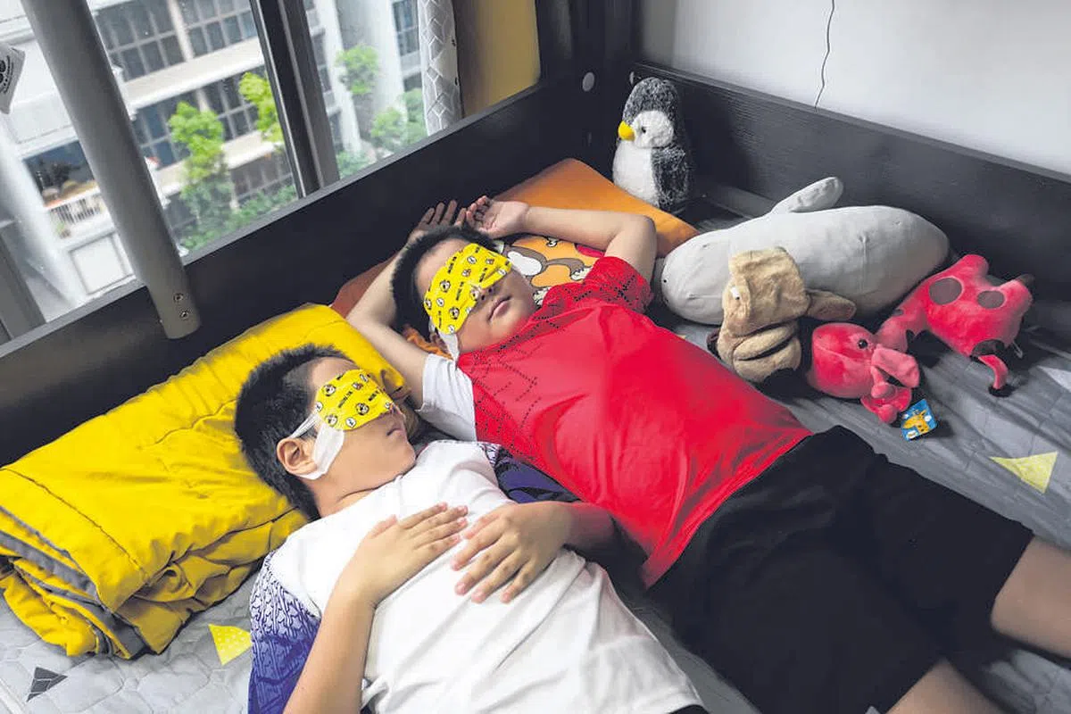 子恩（右）和子恤（左）睡前戴上蒸汽罩来保养眼睛。（图片：叶振忠摄）