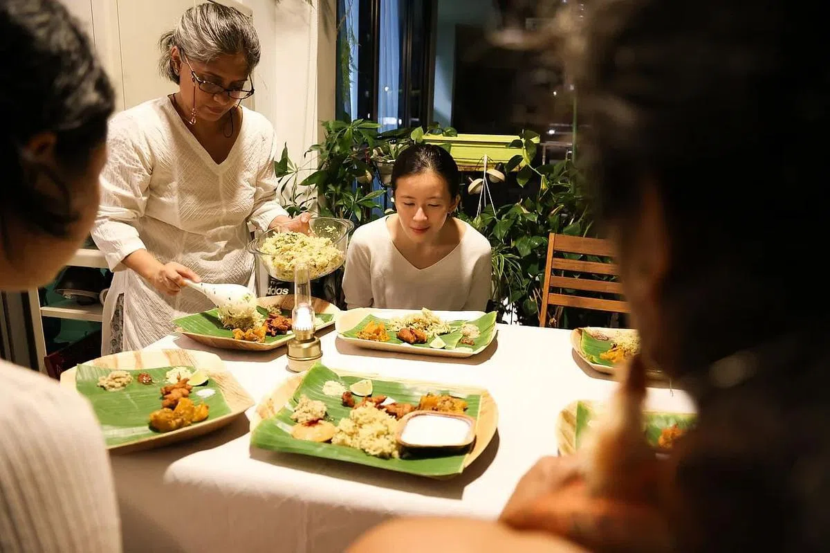 Vishakha（站立者）坚持用塔利方式招待客人，将菜肴盛到客人面前的香蕉叶上。（李冠卫摄）