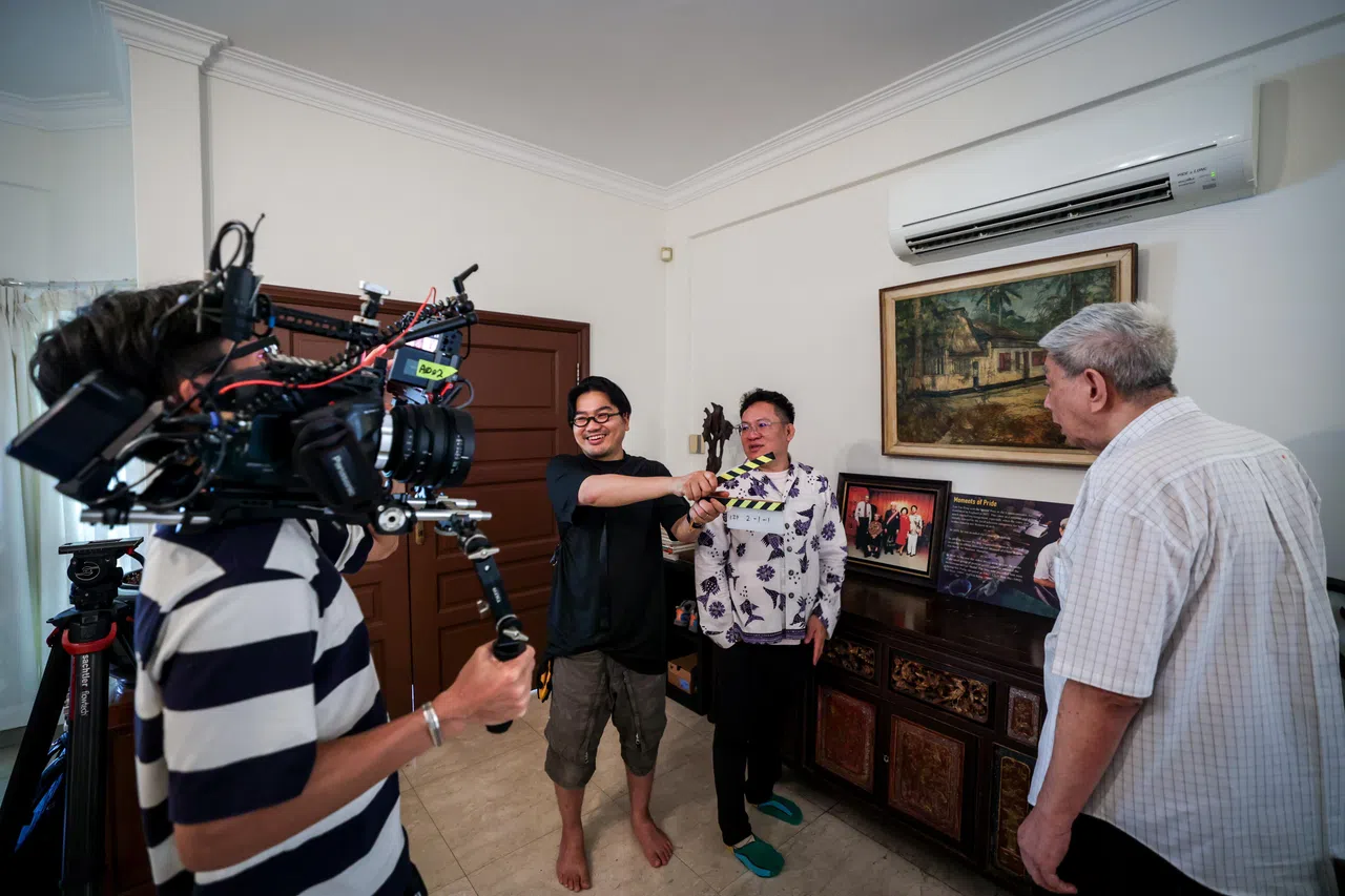《艺述岛国》团队走进林子平的生活空间，记录他人生最后的影像，是一份难能可贵的情缘。林子平长子（右起）向编导林方伟（右二）与总导演廖捷凯（右三）展示林子平年轻时画的甘榜老家。（叶振忠摄）