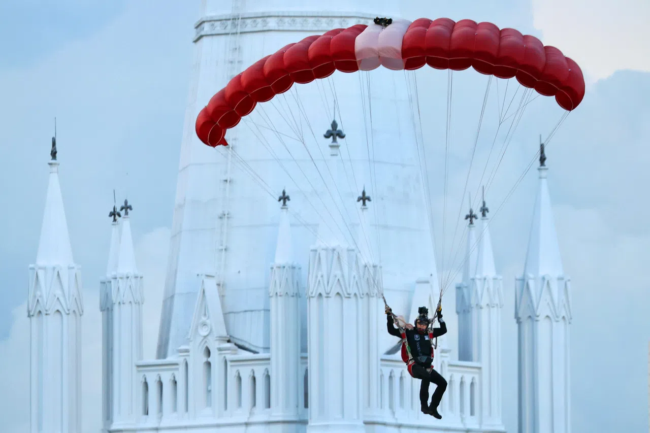 红狮跳伞环节是每年国庆庆典的亮点之一。今年八名红狮如以往为观众带来精彩表演；红狮顺利降落，观众的喝彩声连连。（林明顺摄）