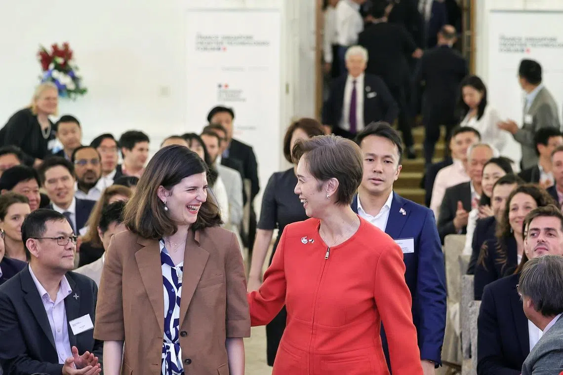 5月30日于富丽敦酒店，新加坡数码发展及新闻部长杨莉明（红衣者）迎接法国人工智能与数字经济部长代表克拉拉·夏帕兹，共同为法国—新加坡前沿技术论坛主持开幕仪式。（海峡时报）