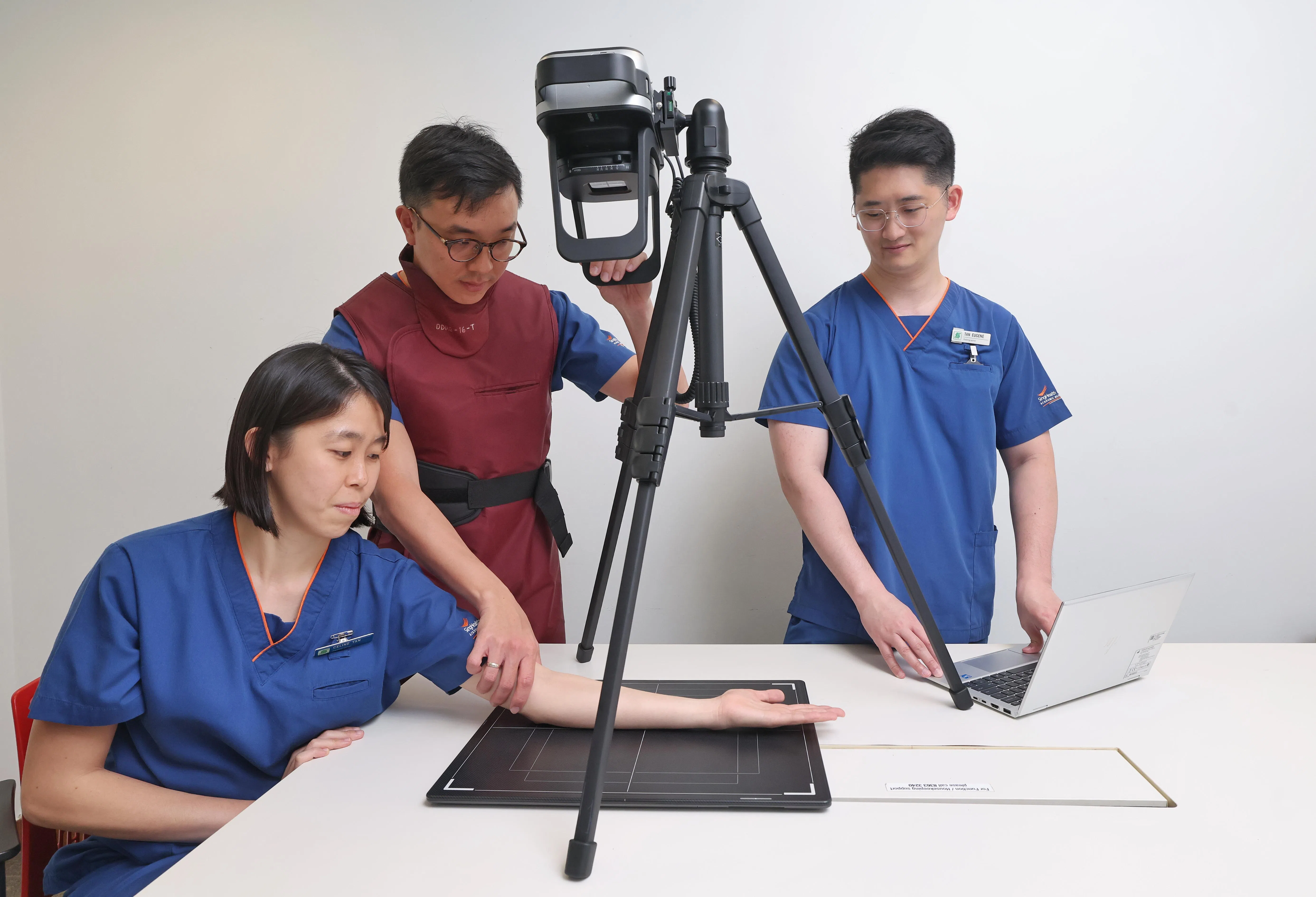 新加坡中央医院高级首席放射师陈盈利（左起）、高级首席放射师沈韦佑及放射师陈祐祺，示范这款设备搭配不同支架，可以针对不同身体部位拍摄X光。（唐家鸿摄）