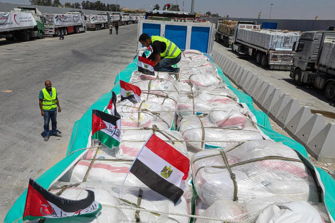 8月6日，救援人员在埃及和加沙地带之间的拉法口岸埃及一侧处理要运往加沙地带的物资。（法新社）