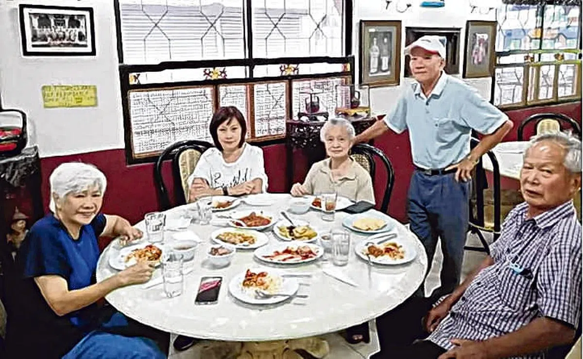 吴丽娟（左三）和照料墓地的马六甲友人合影。（林松提供）