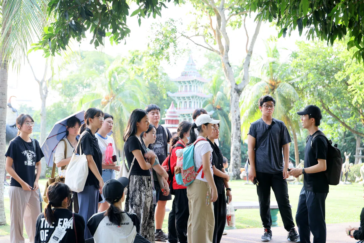 年轻写作爱好者正专心聆听导师梁海彬（右一）讲解文史。（龙国雄摄）