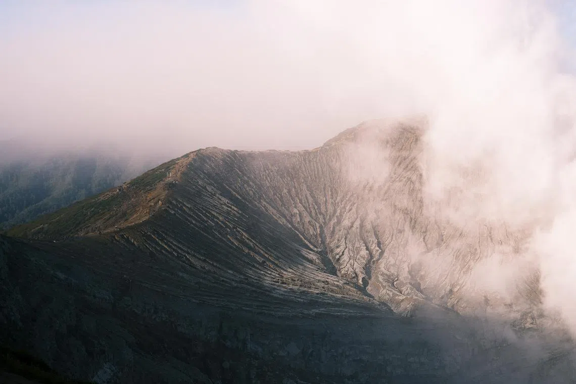 当风向改变时，硫磺烟雾会飘向火山口边缘的登山步道。（钟俊鸿摄）