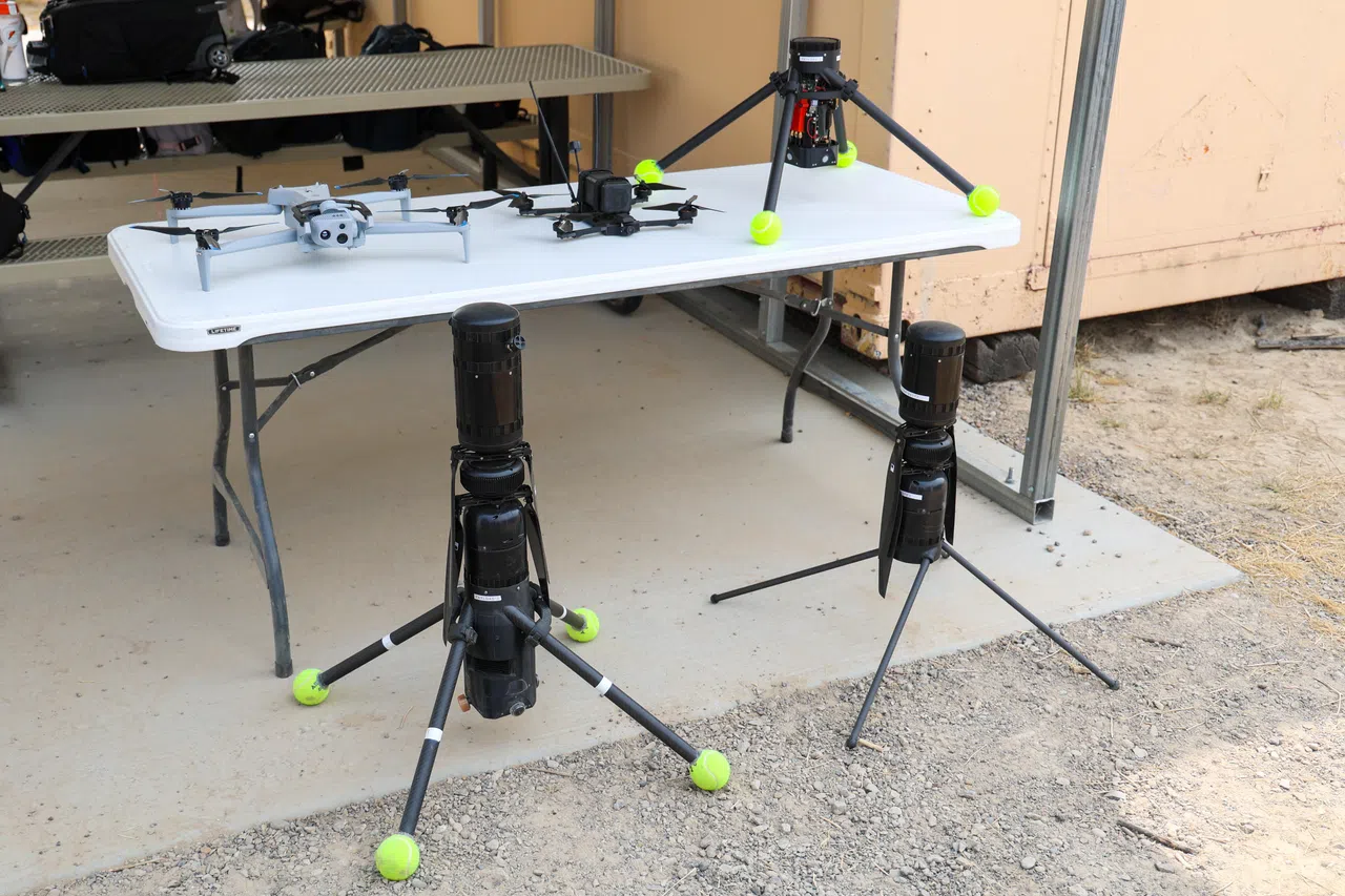 Ascent Spirit是空军部队在铸刀演习中测试的其中一款商用无人机。前排右为原装机型，左为加装了国防科技局研发的自主算法模块，相当于装上“智能大脑”，让一名操作员可同时调度多架无人机，执行群飞任务。升级后的Ascent Spirit在起落支架上加装网球，以增强松软沙地上的稳定性。（林明顺摄）