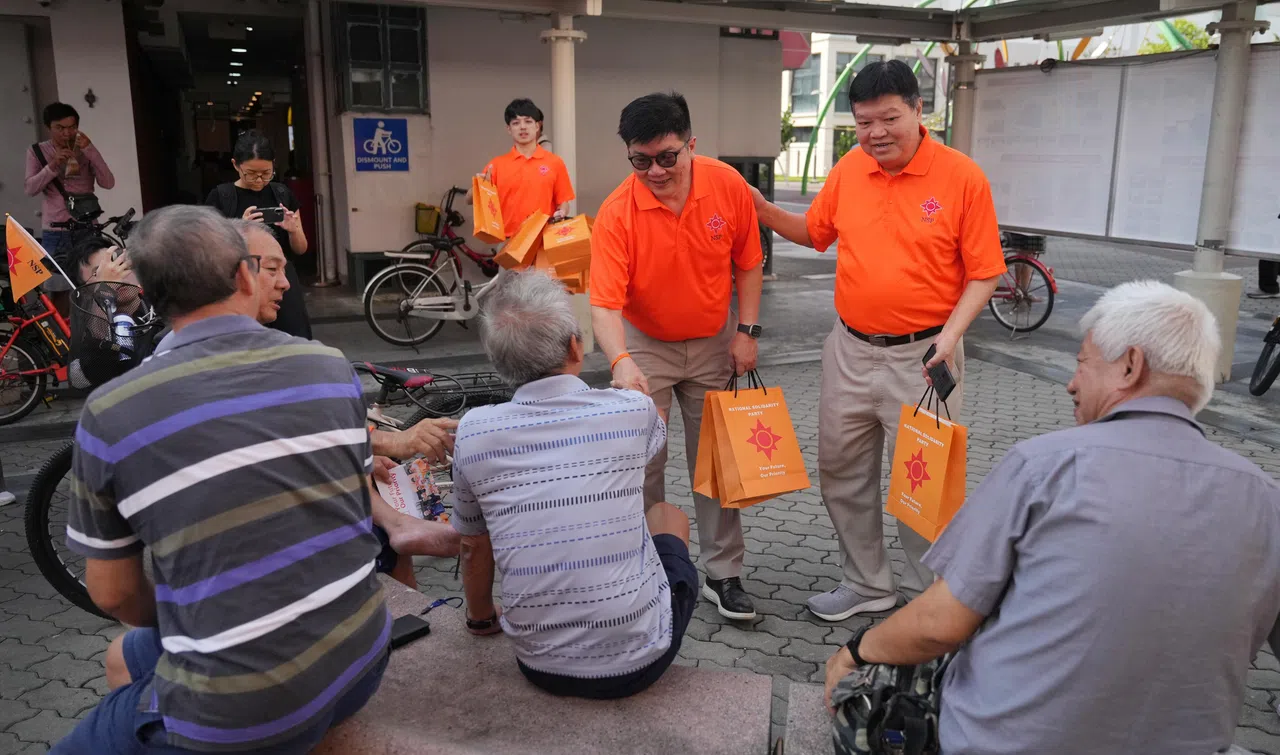 国民团结党的彭伟杰（面对镜头，左）、党主席冯展良（中），以及前主席张培源（右）星期二上午走访淡滨尼4道第820座组屋一带，与居民交谈。（谢智扬摄）