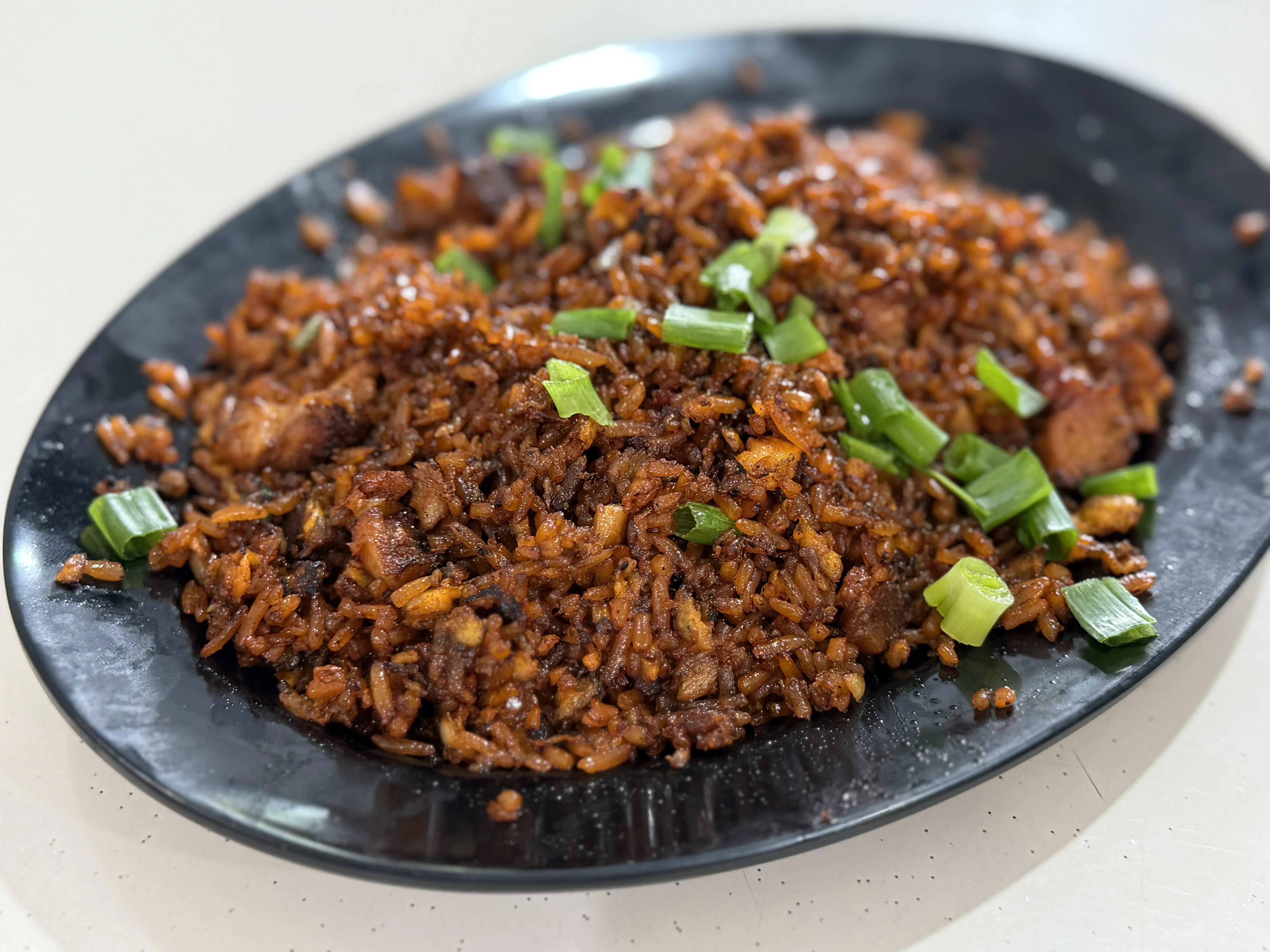 阿发炒饭是摊主母亲的秘制家常味，炒饭颜色偏红棕色。（叶晓虹摄）