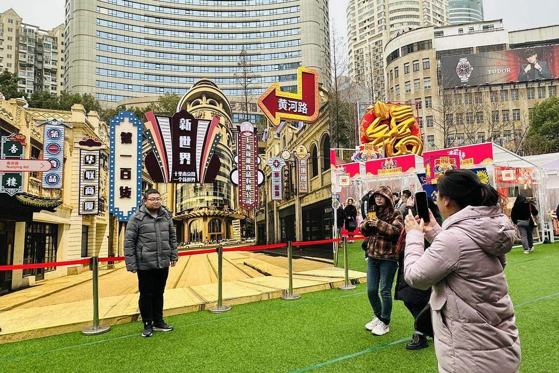 南京路步行街的龙年市集中央，是一整面仿照《繁花》年代南京路搭建的打卡墙，吸引不少游客上前合影。（陈婧摄）