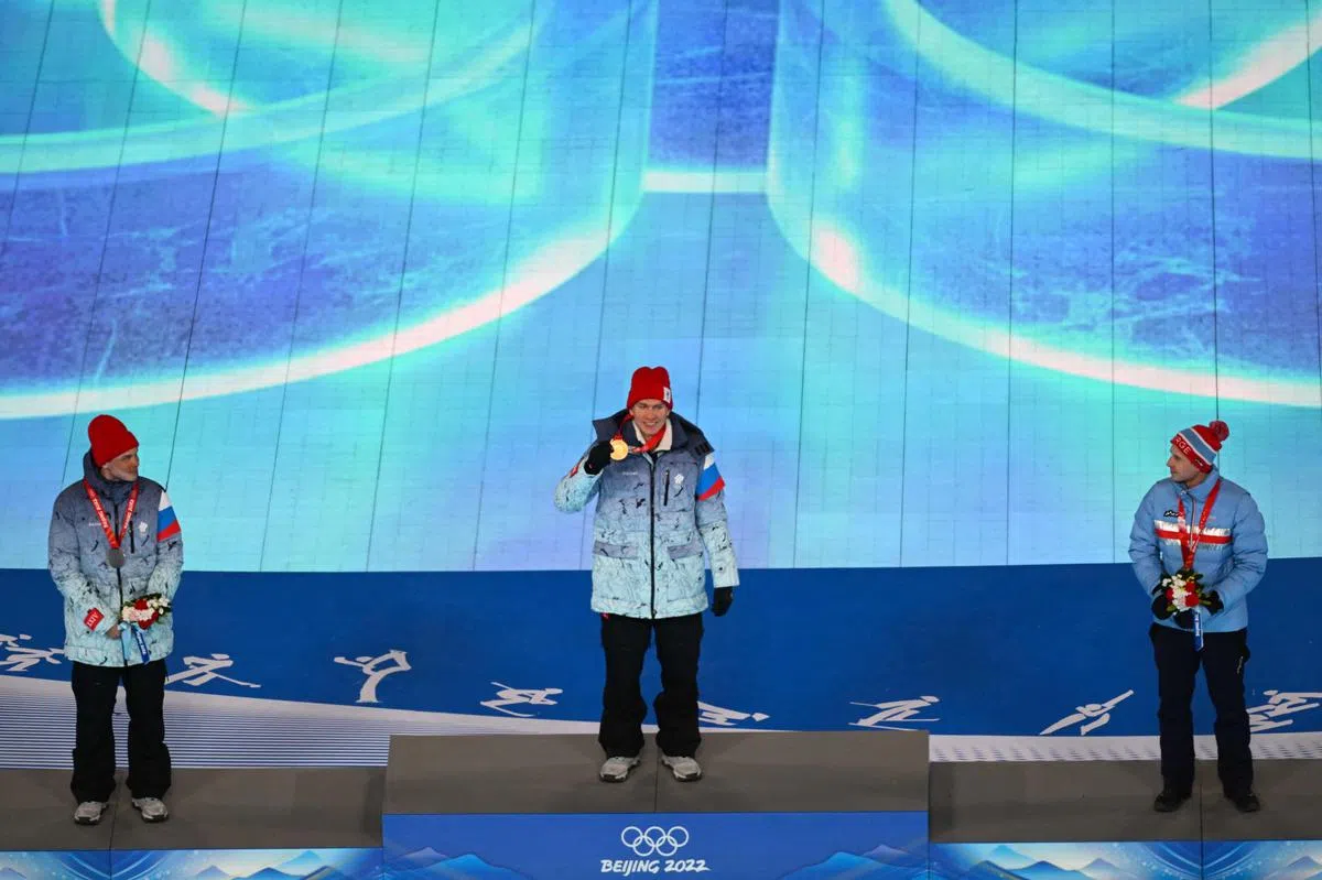 在北京冬奥会越野滑雪男子50公里集体出发项目夺得金牌的俄罗斯选手博尔舒诺夫（Alexander Bolshunov，中），在闭幕上获颁奖牌，同样来自俄国的亚基穆什金（Ivan Yakimushkin，左），以及挪威选手克鲁格（Simen Hegstad Krueger，右）则分别获得银牌和铜牌。（法新社）