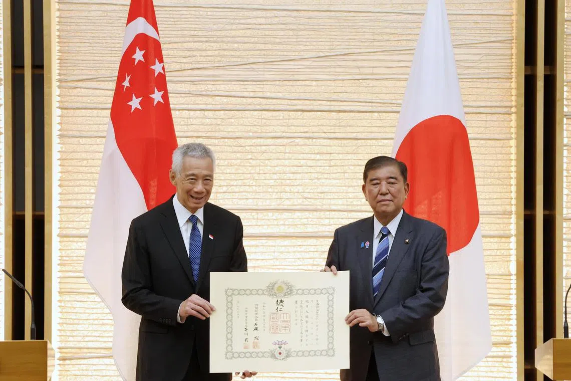 日本首相石破茂（右）在官邸内举行仪式，代表天皇授予李资政旭日大绶章。（数码发展及新闻部提供）