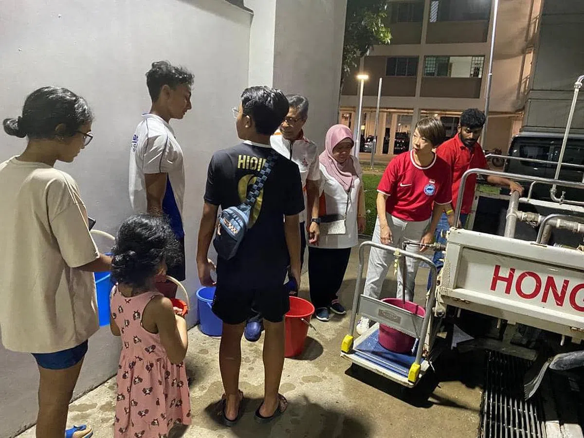 西海岸集选区议员胡美霞（右二）协助居民取水。（取自胡美霞脸书）