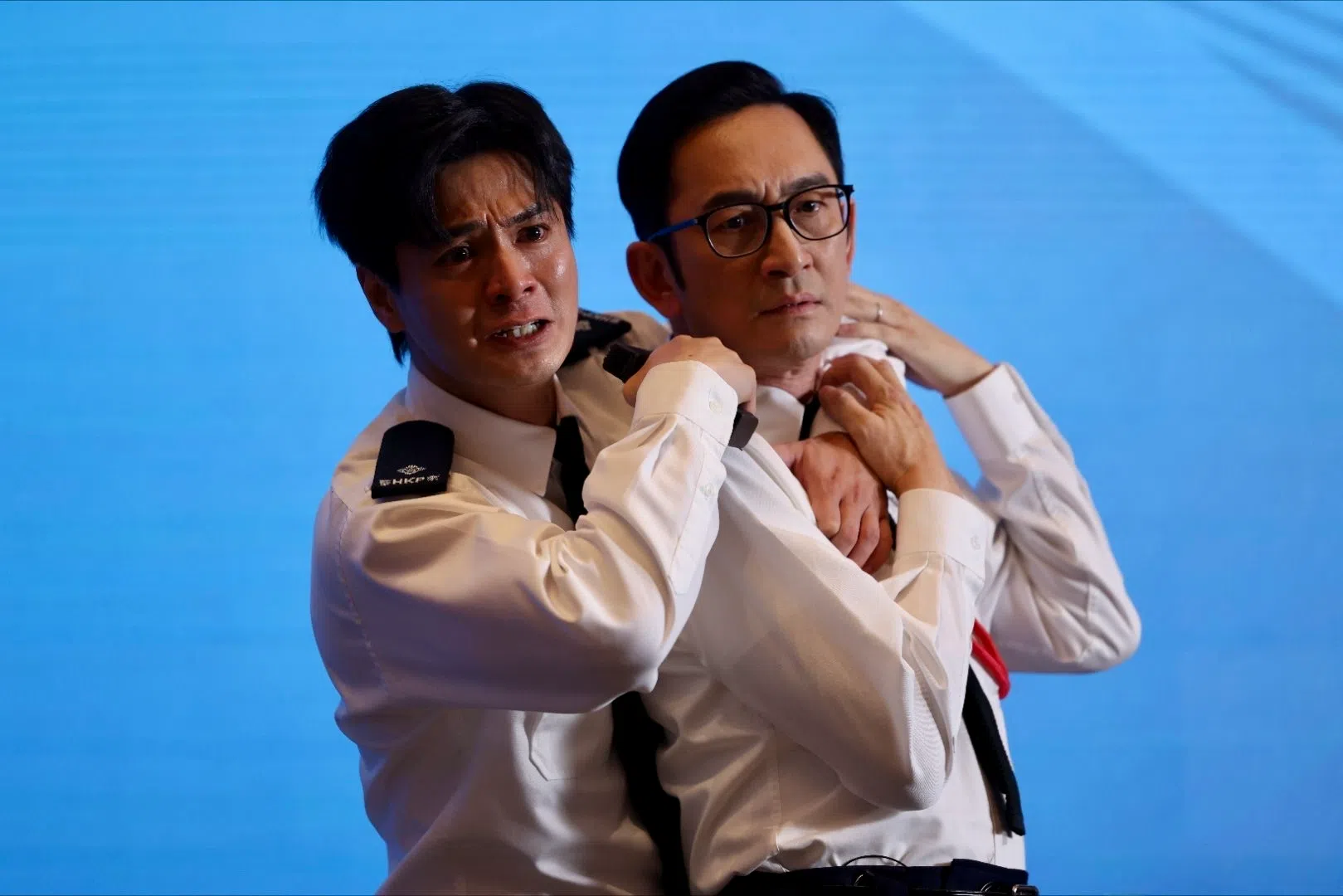 接近尾声的一场戏，罗子溢（左）在众人面前挟持吴启华（右）饰演的“终极大反派”，将其黑警恶行公诸于世后自轰身亡。（互联网）