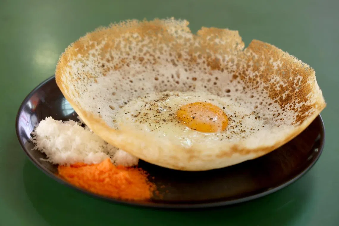 半生熟蛋黄流淌出滑嫩口感，混合糖和椰丝，带来不一样的阿榜体验。（龙国雄摄）