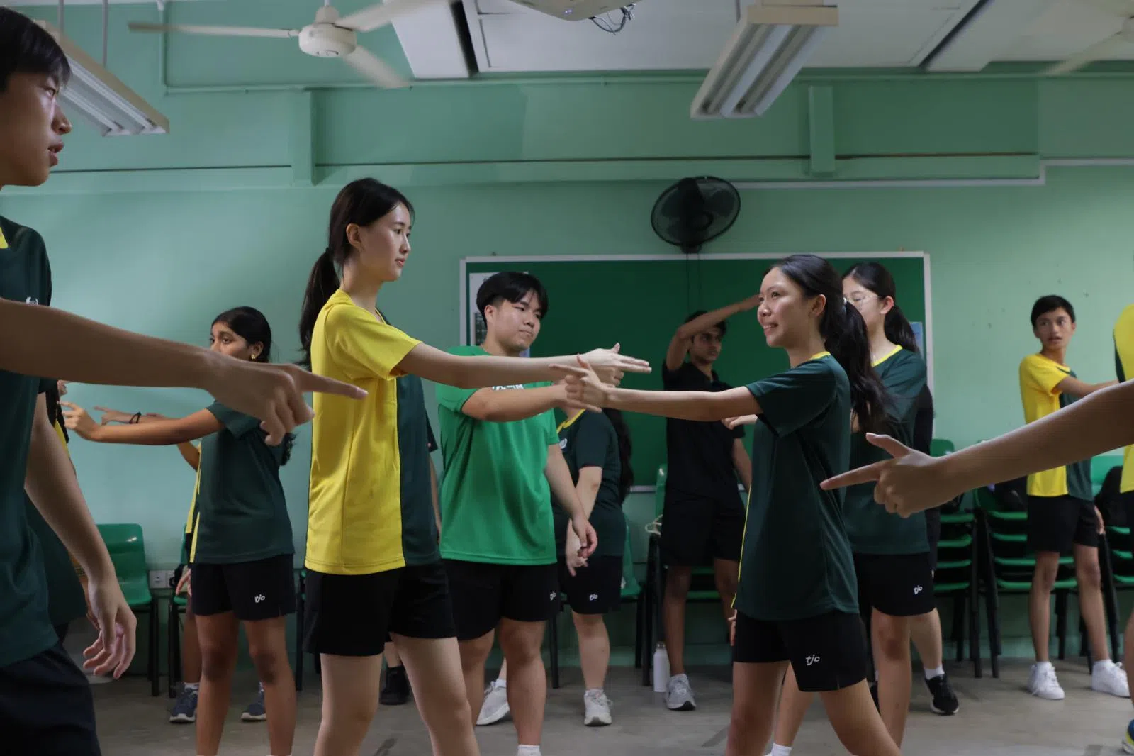 新生整齐划一的舞步，在欢快的节奏中尽情舞动。（淡初摄影社提供）