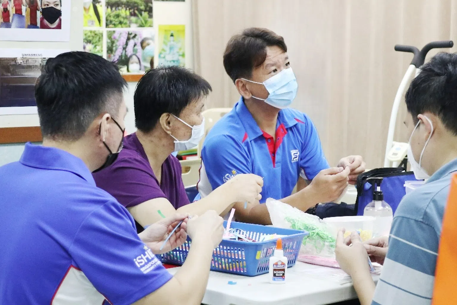 职员义工在慈光乐陶苑及智障日间活动中心，与智障人士一起做手工。（图/新加坡博彩公司提供）