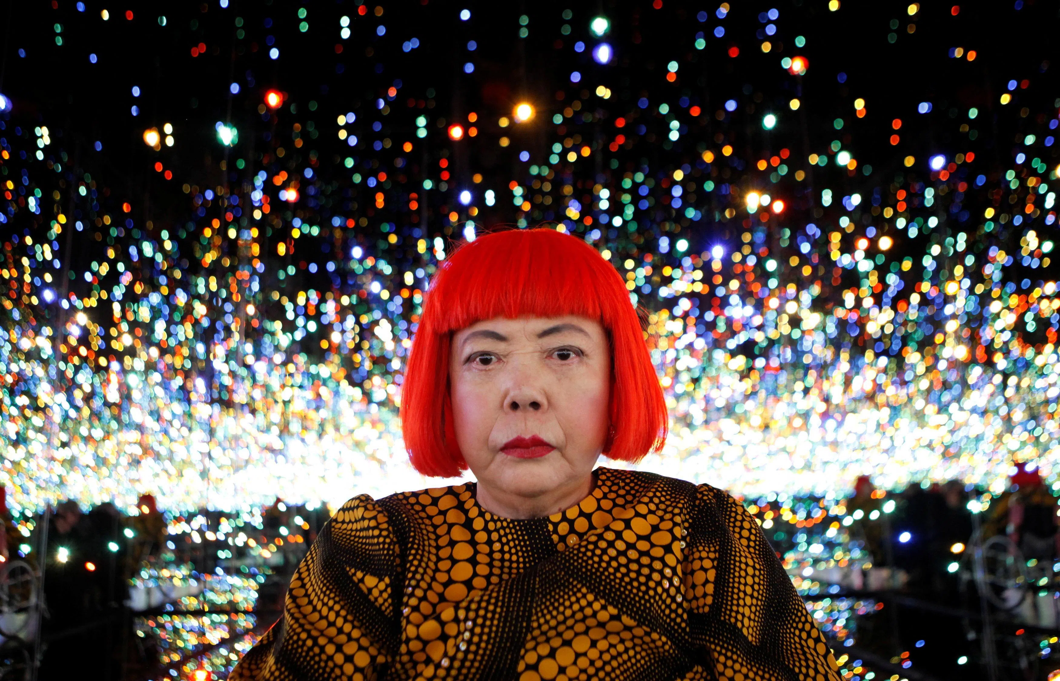 日本前卫艺术家草间弥生2013年纽约个展，与其著名的无限镜室作品合影。（路透社）