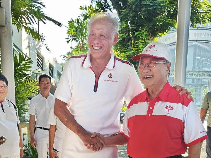 陈清木（右）与黄永宏（左）握手相互友好问候。（海峡时报）