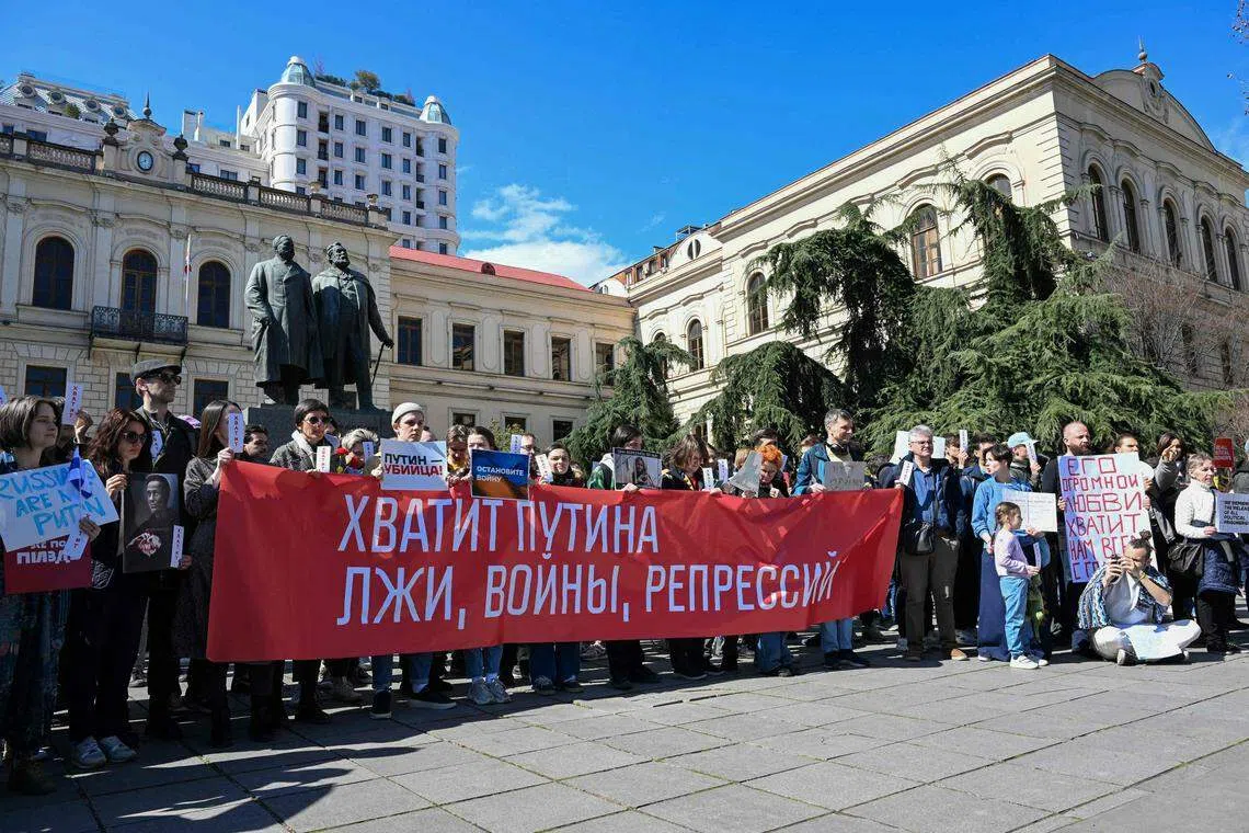 3月17日，旅居格鲁吉亚的俄罗斯侨民在第比利斯的抗议活动上举着写有“受够了普京、谎言、战争和镇压”的横幅。（法新社）