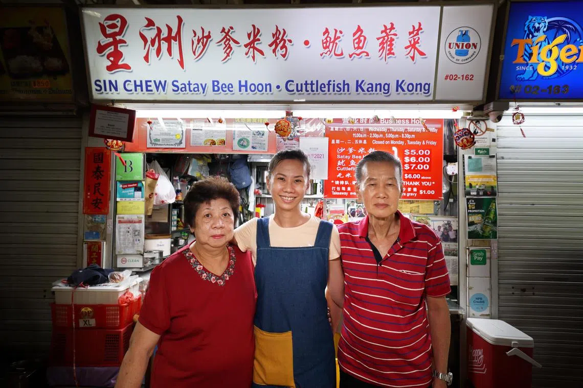郑慧婷（中）当年毕业后不久便接手父亲郑启发（右）和母亲许玉定（左）的沙爹米粉生意。（龙国雄摄）