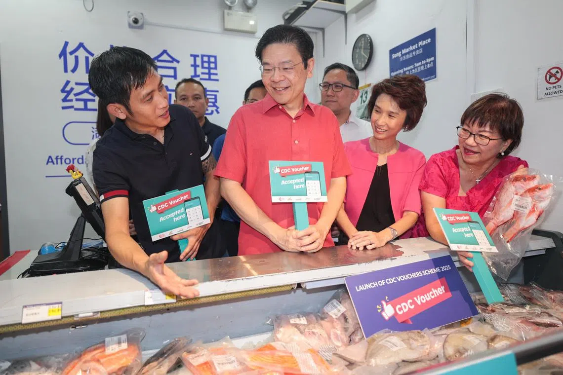 政府在本财年分两次对每户公民家庭派发总值800元的社理会邻里购物券（CDC Vouchers）。图为黄循财总理（中）到义顺南民众俱乐部出席最新一轮邻里购物券推介活动后，走访附近超市和邻里商店，了解购物券的使用情况。（档案照片）