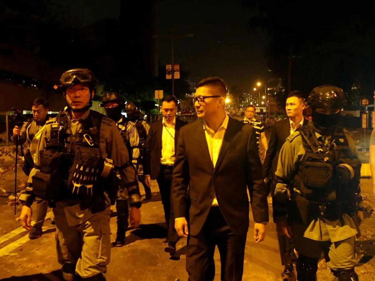 2019年11月19日22时许，邓炳强在数名防暴警察的陪同下，到理工大学外围的康庄道巡视，与前线指挥官交谈。（互联网）