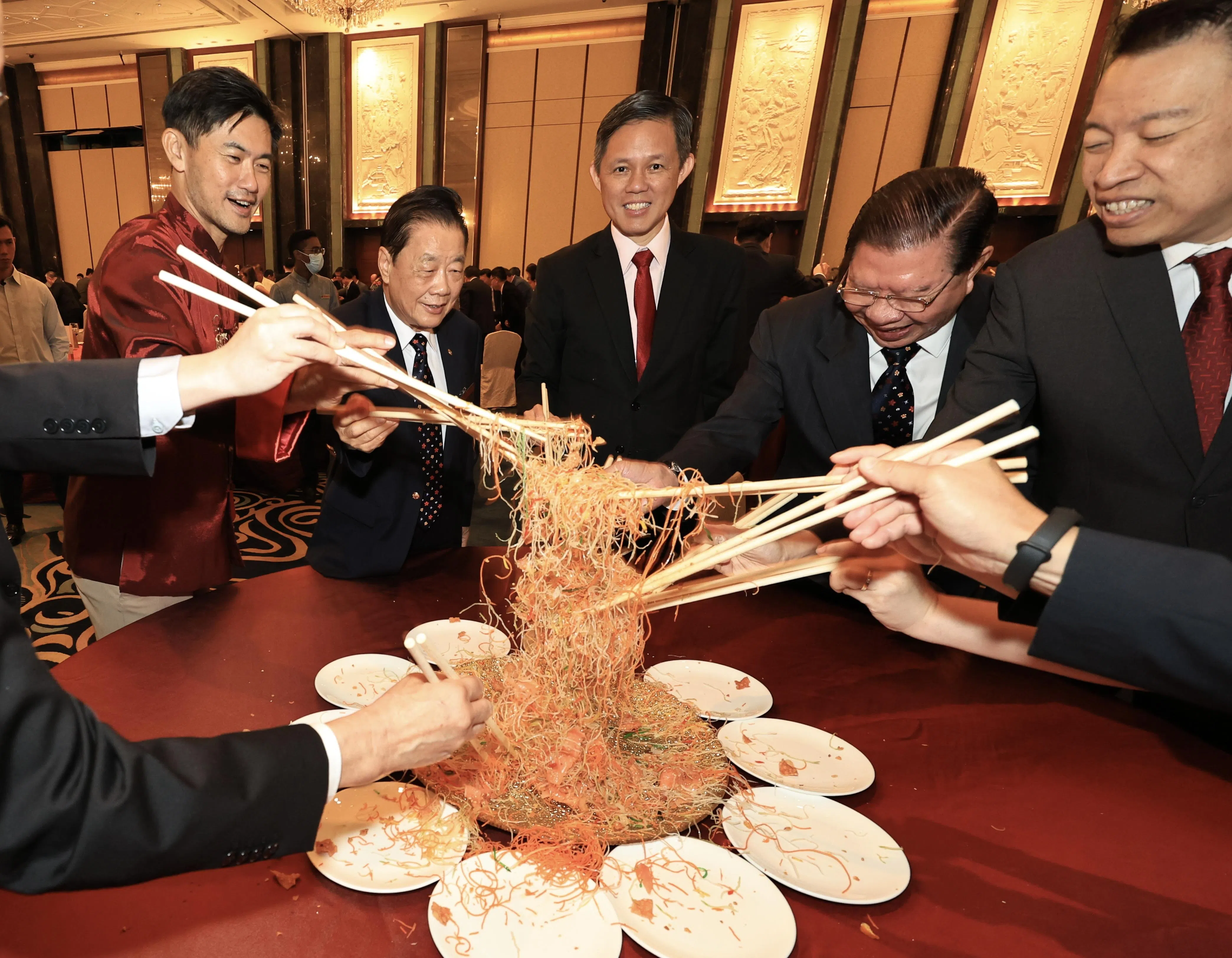 总理公署政务部长陈国明（左起）、广东会馆会长何国才、教育部长陈振声、广东会馆高级永远荣誉会长黄遂粲和拉丁马士区议员杨益财等人， 在广东会馆新春团拜午宴上一起捞鱼生。（特约陈来福摄）