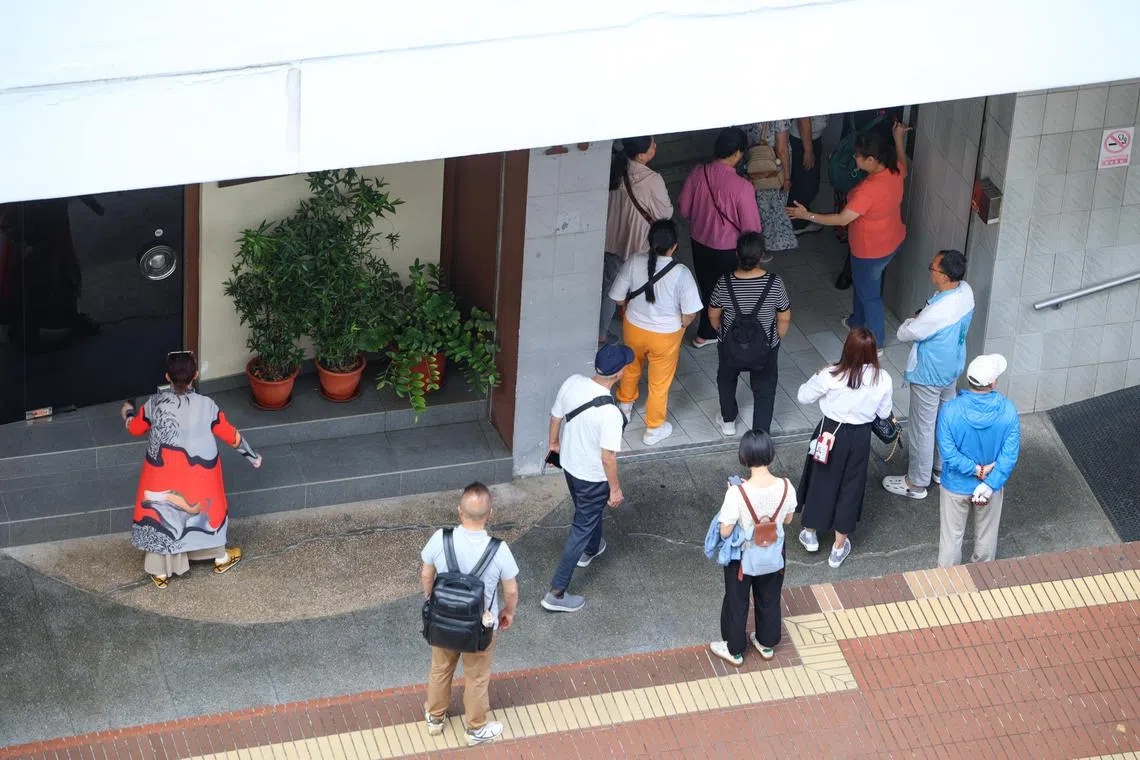 从早上10时起，陆续有载着游客的旅游大巴来到店外，每辆车至少15人。两名女员工负责在一楼电梯口接待，一些穿制服的员工则在楼上带着对讲机。（关俊威摄）