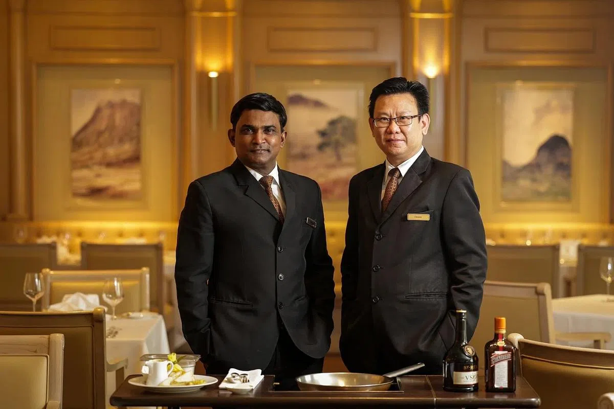 餐馆经理洪友良（右）和服务员尚穆根，在Gordon Grill服务多年。（叶振忠摄）