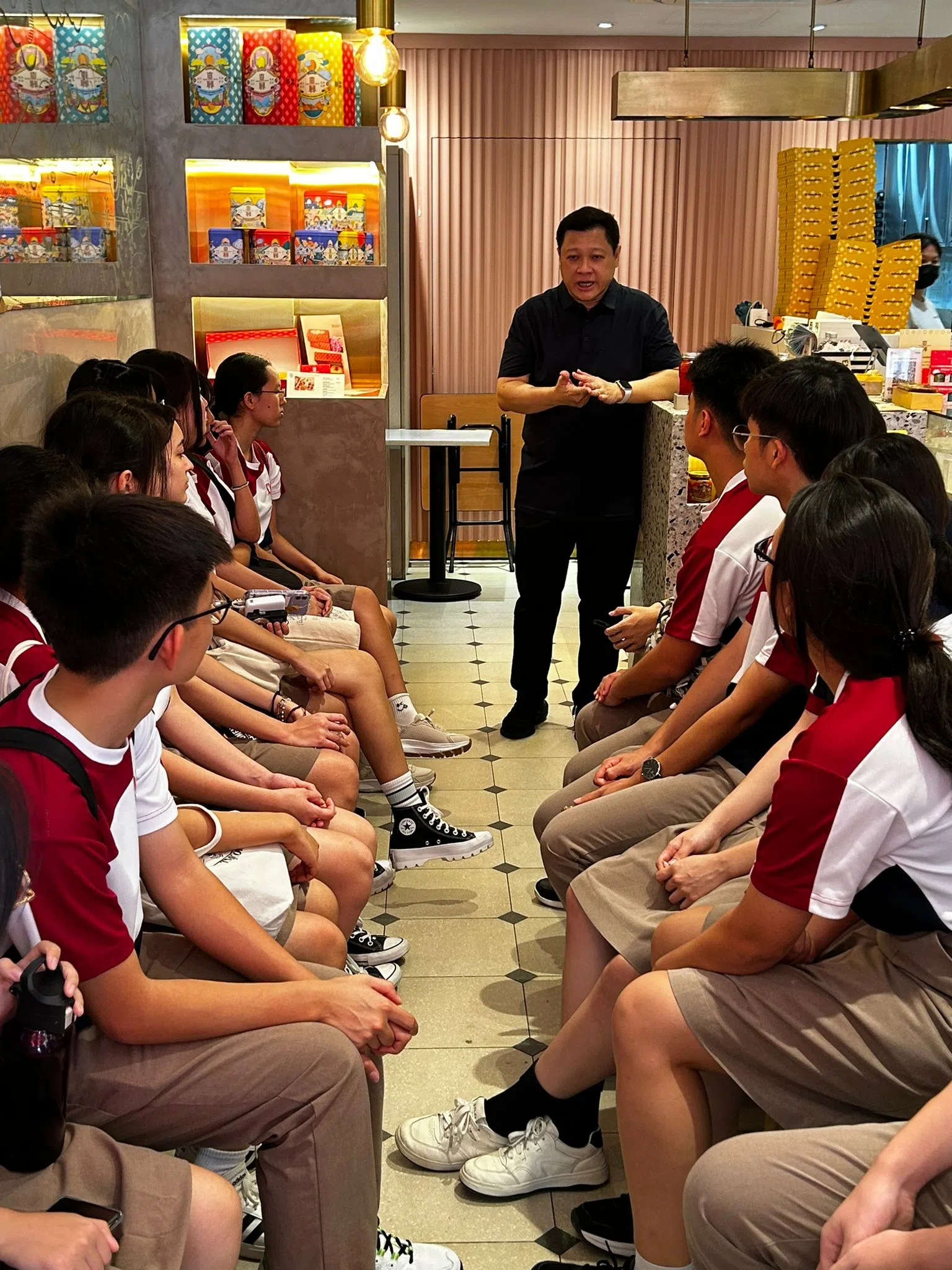 东兴饼家的方惠强为学生讲述老饼店的创业故事。（淡滨尼美廉初级学院提供）