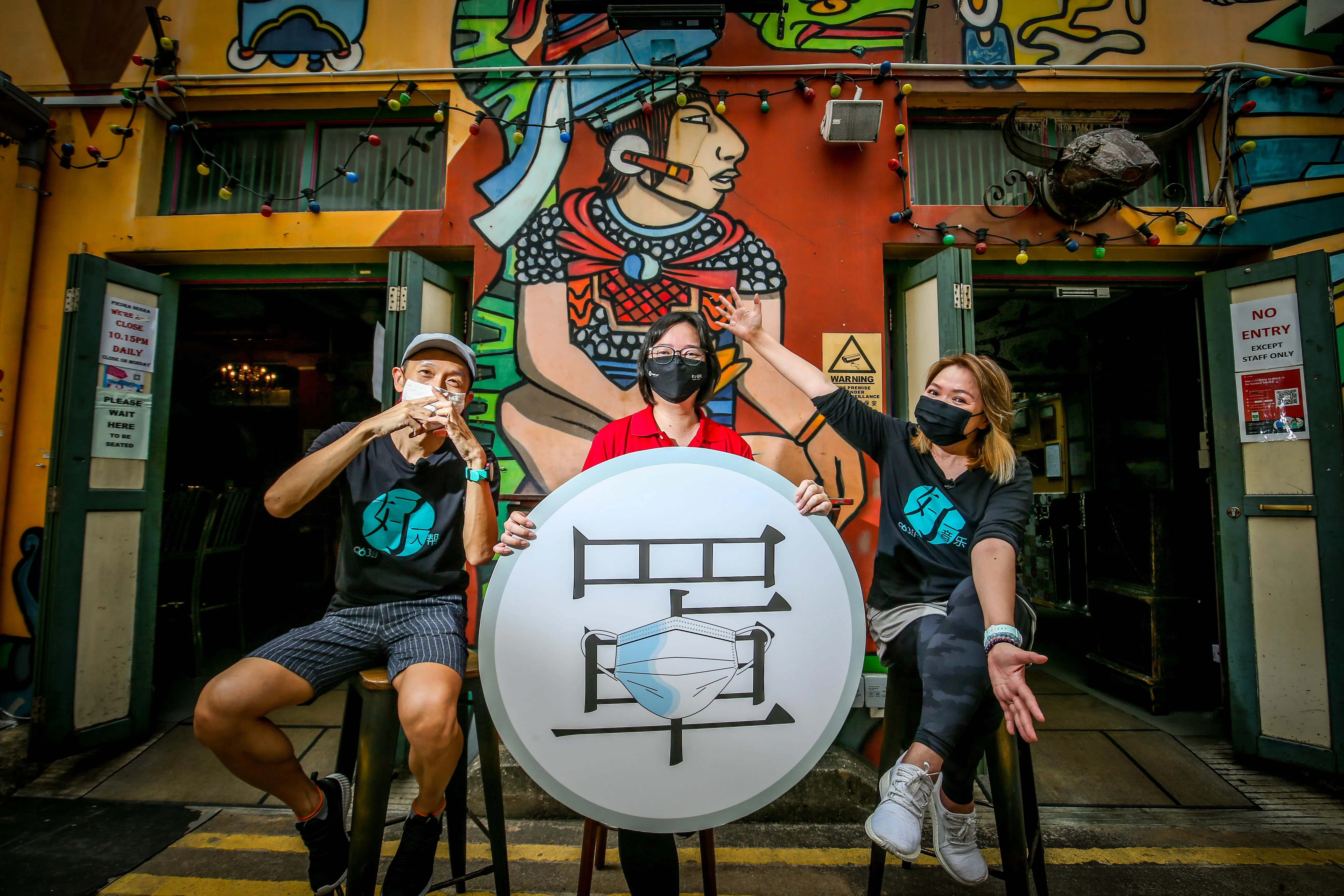 因为冠病疫情，《联合早报》“字述一年2020”汉字投选活动的年度汉字揭晓节目预先录制，于12月14日在网络首播。汉字投选结果出炉，“罩”字以2415票大幅领先，当选年度汉字。新闻中心数码编辑副主任李丽敏（中）在脚踏车路线的终点——哈芝巷，与96.3好FM DJ洪菁云（右）和王德明一同揭晓年度汉字。（叶振忠摄）